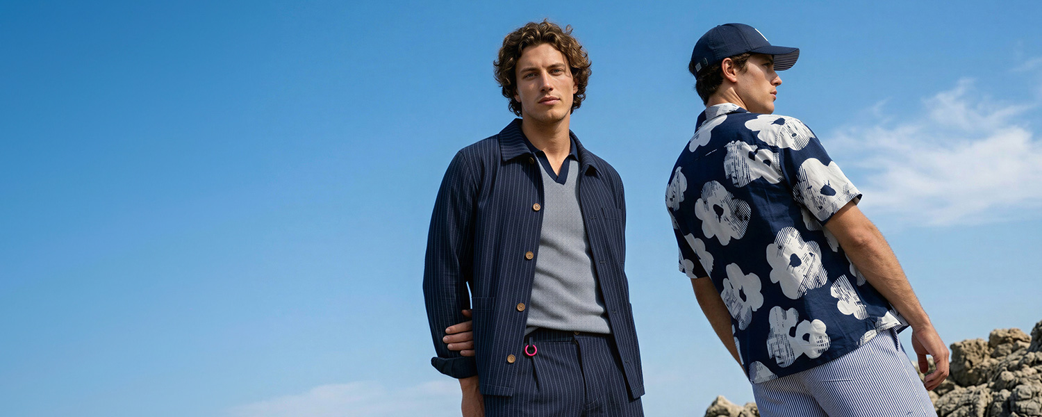 Herren in blauer Strickjacke mit grauem Shirt und kariertes Freizeithemd im Blumendesign, leger getragen