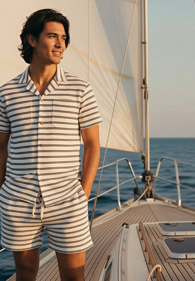 Gestreiftes Kurzarm-Shirt und Shorts-Set in Weiß-Beige auf Segelboot getragen