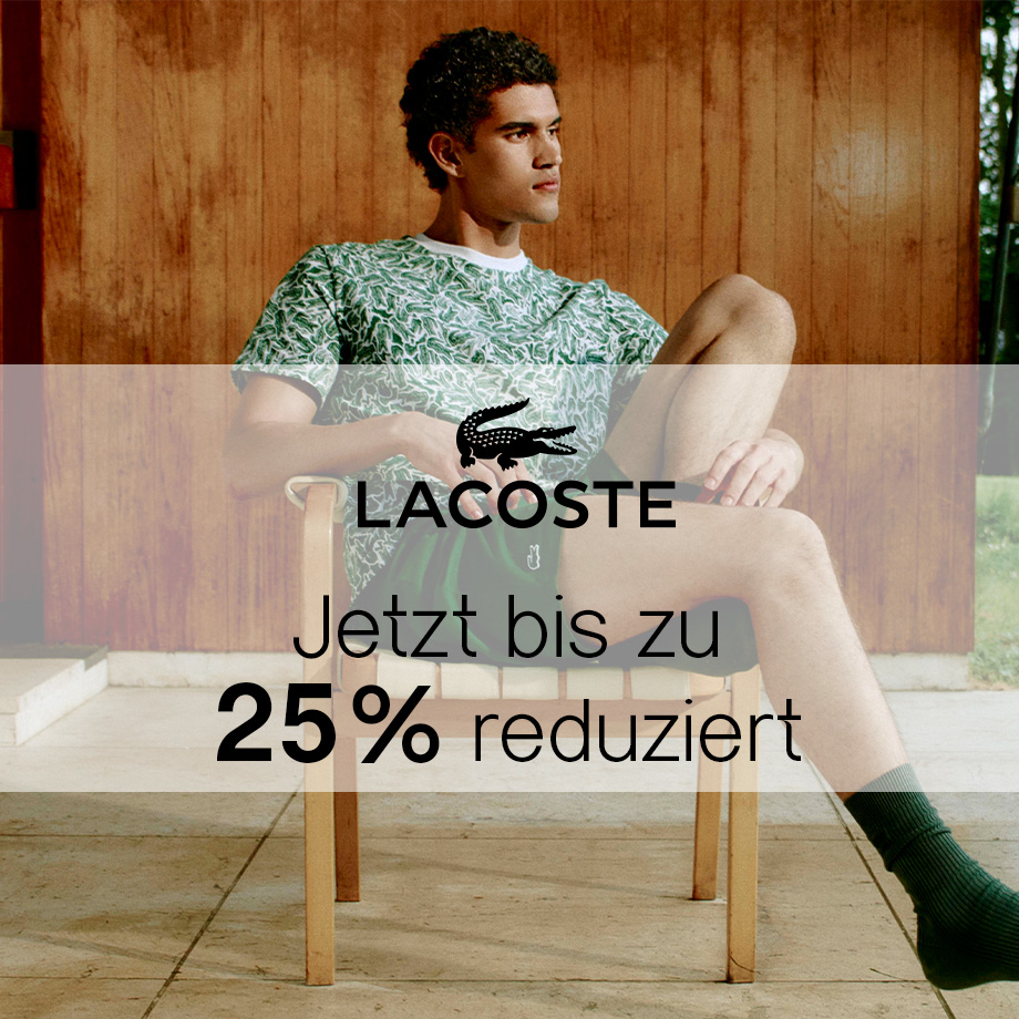 Herr in grün gemustertem T-Shirt und Shorts, sitzt entspannt auf einer Terrasse.