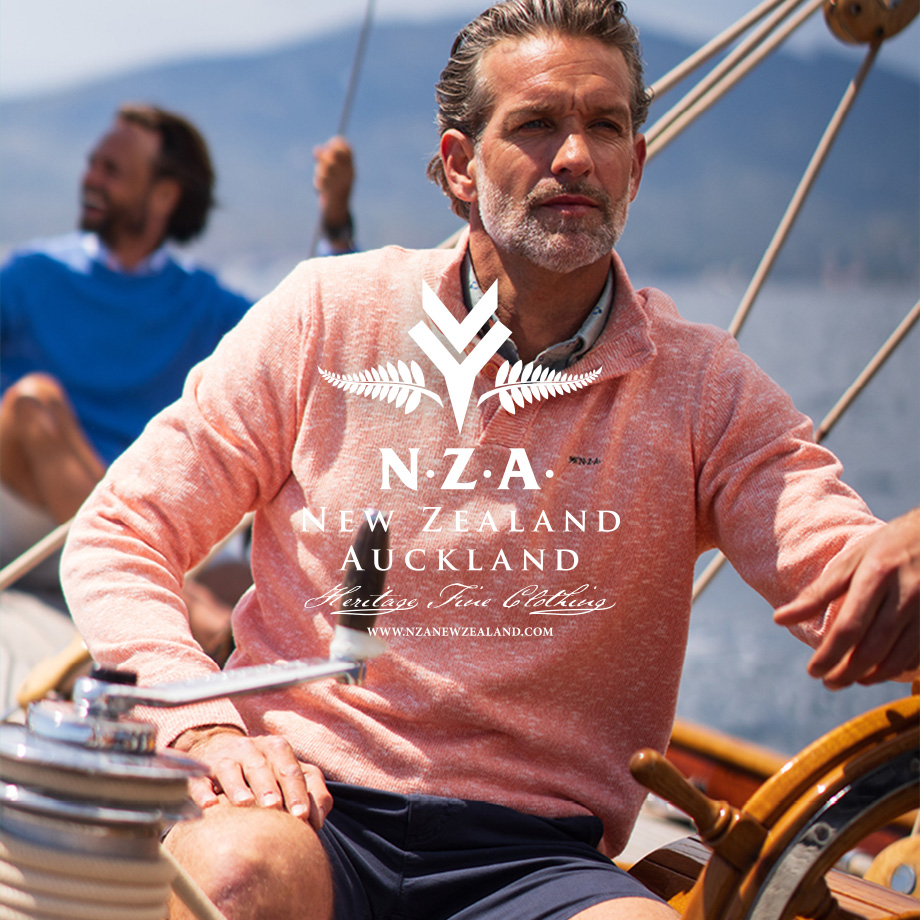 Herr in korallfarbenem Strickpullover auf Segelboot, legerer Look