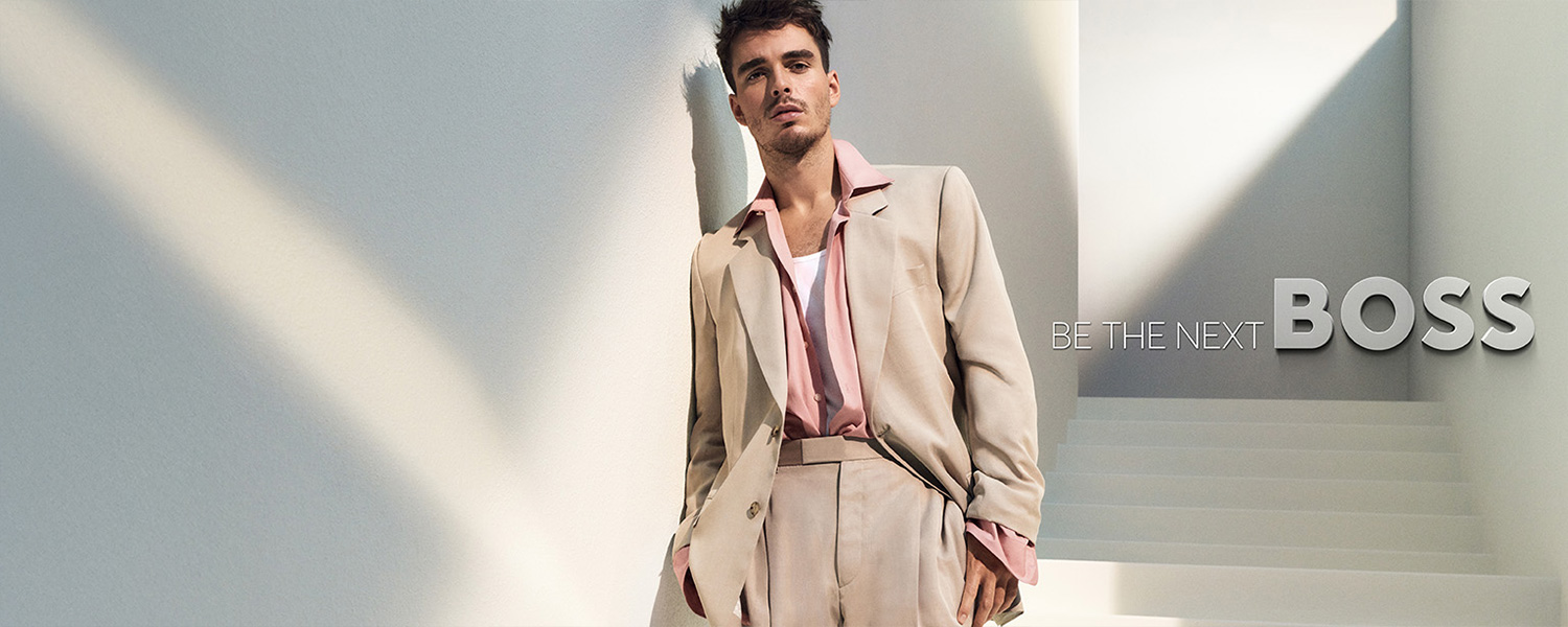 Hellbeiger Anzug mit rosa Hemd offen getragen, lässiger Look, moderne Eleganz