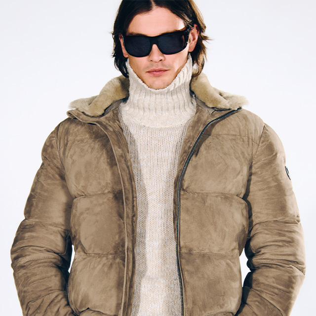 Beiger Winterparka aus Wildleder, über grobem Rollkragenpullover getragen