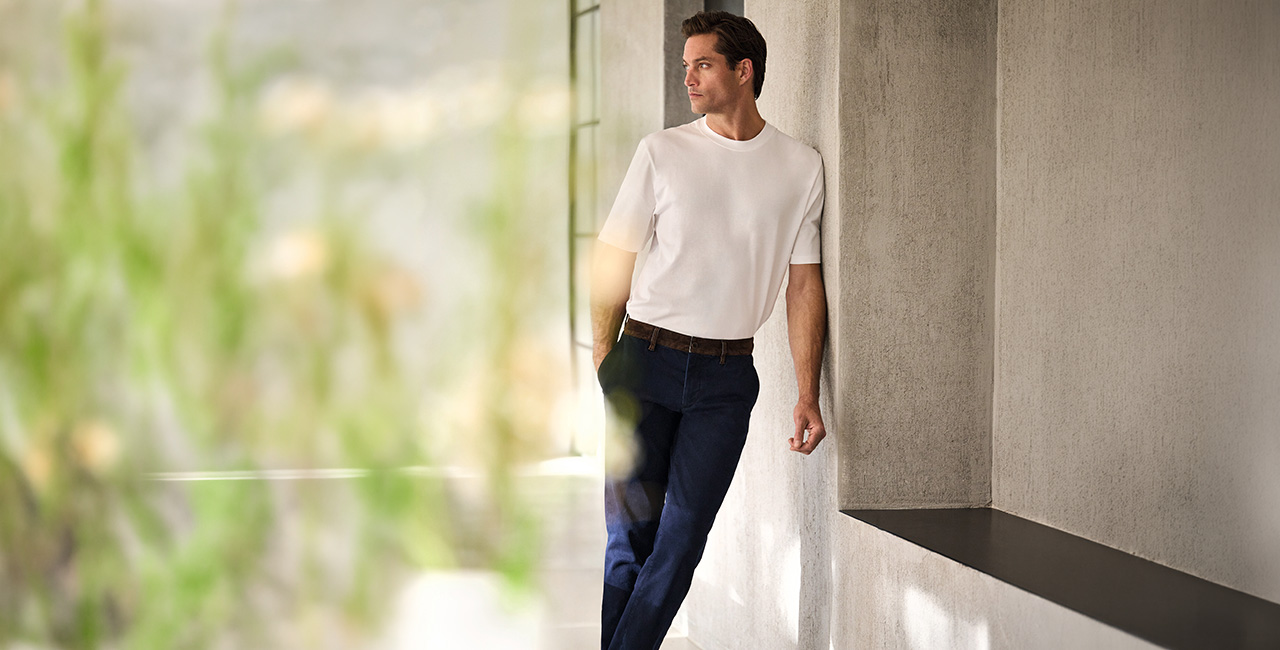 Elegantes weißes T-Shirt aus Baumwolle, kombiniert mit dunkelblauer Hose, lässig präsentiert im modernen Ambiente