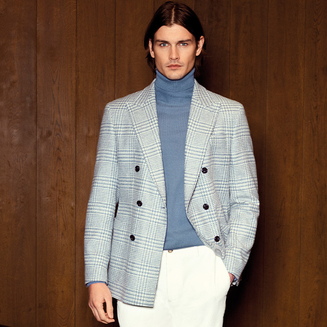 Doppelreihiger Glencheck-Blazer in Hellblau über blauem Rollkragenpullover, weißer Hose