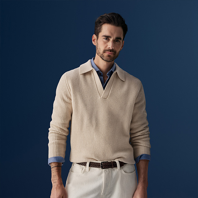 Mann in beigem Strickpullover über blauem Hemd, eleganter Freizeitstil