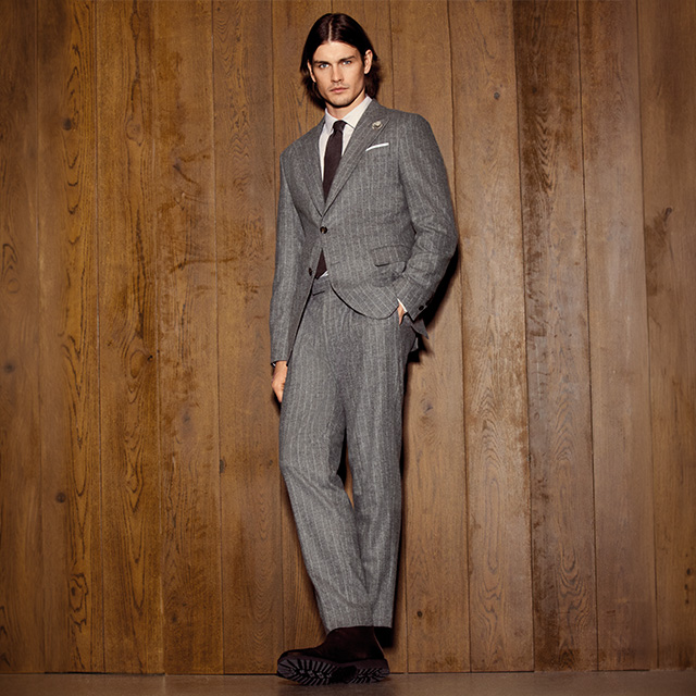 Grauer Nadelstreifen-Anzug aus Wolle, Mann im Anzug vor Holzwand, Business-Look