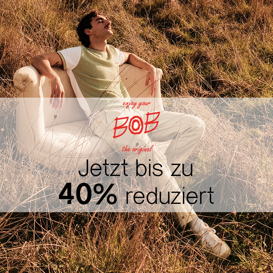 Mann in hellgrünem Poloshirt aus Baumwolle mit weißen Hosen auf Sessel im Freien