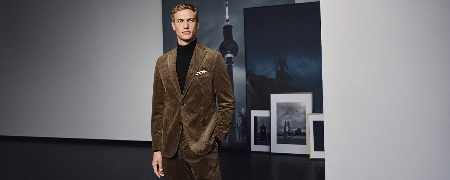 Brauner Cordanzug, schwarzer Rollkragenpullover, Mann elegant im Kunststudio