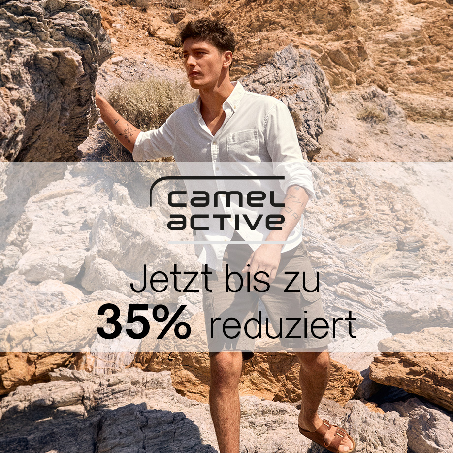 Mann in weißem Leinenhemd und kurzen Hosen auf Felsen in entspannter Umgebung