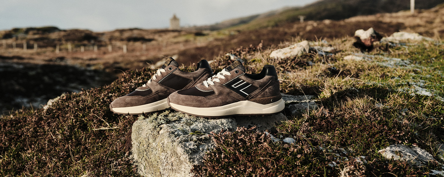 Braune Sneaker aus Wildleder auf Naturstein, sportlich-elegantes Design