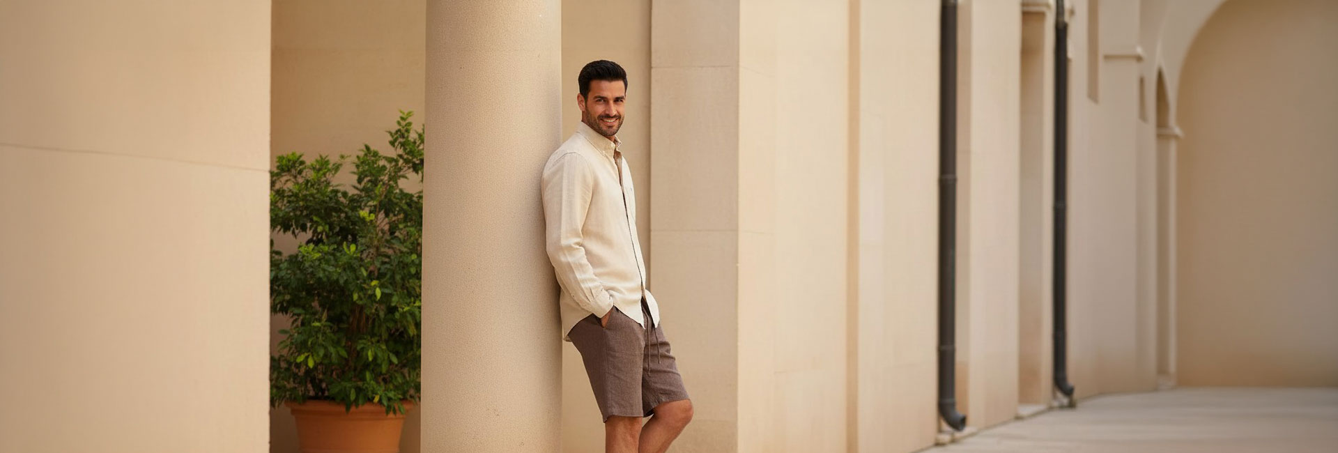 Beiger Leinenblazer für Herren, kombiniert mit braunen Shorts, lässig getragen im Freien.