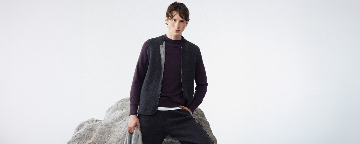 Mann in anthrazitfarbener Strickjacke mit lila Pullover, lässig kombiniert