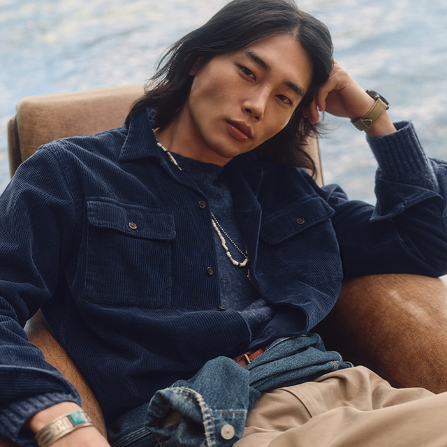 Mann in blauer Cordjacke, lässig sitzend, kombiniert mit beigem Chino, Freizeit-Look
