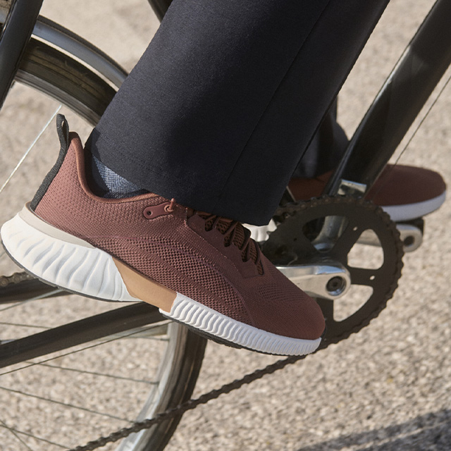 Rostbrauner Sneaker aus Mesh, weiße Sohle, getragen beim Fahrradfahren