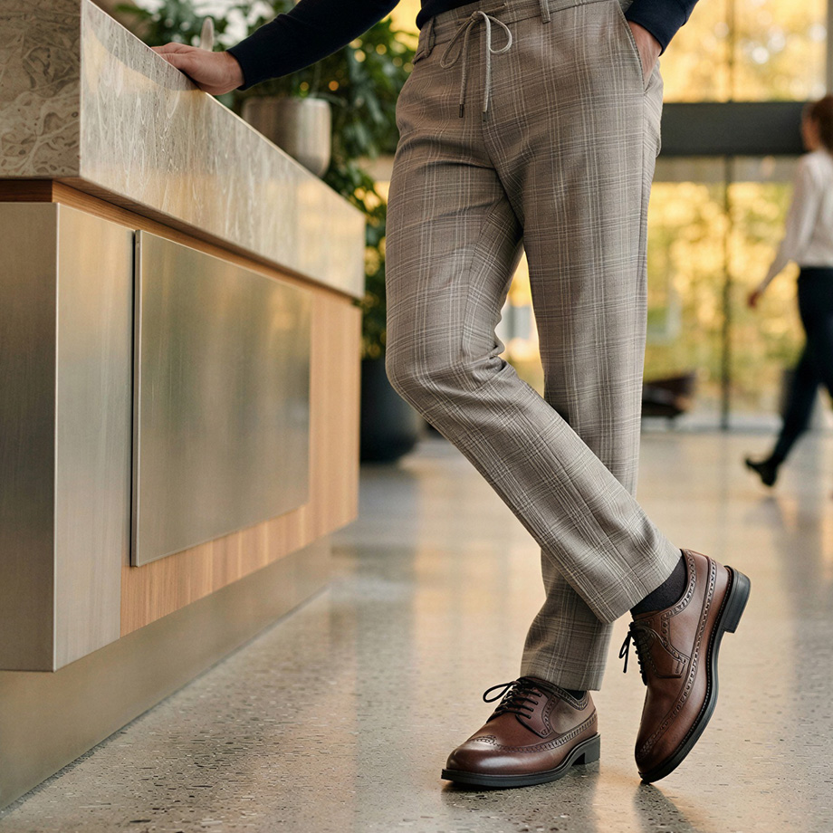 Beige karierte Business-Hose aus Wolle, getragen mit braunen Lederschuhen in Büroambiente